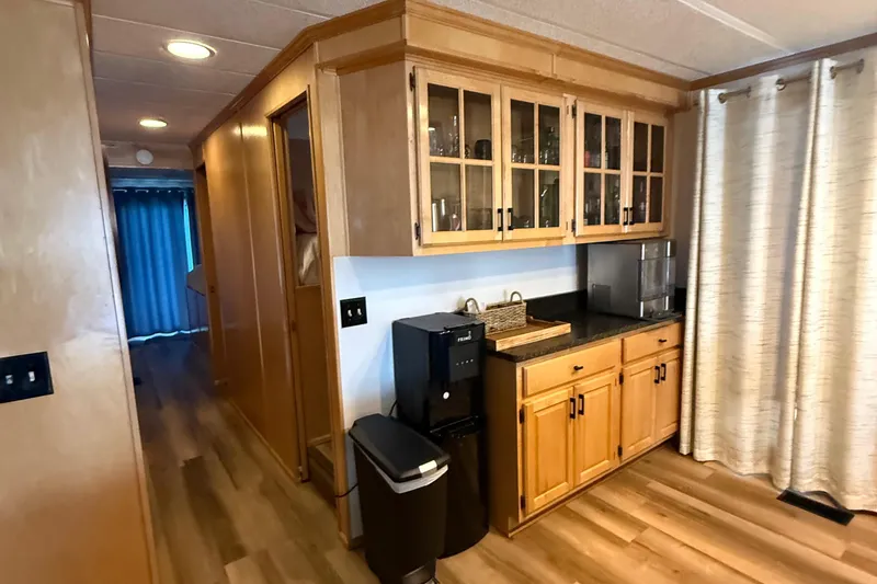 Slide: The Image of 2003 Horizon houseboat interior with wooden cabinets, black countertop, and modern appliances. - 13