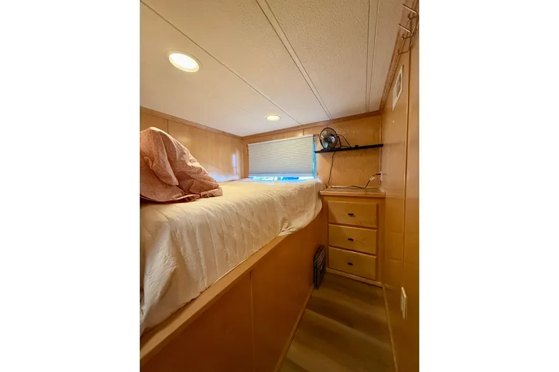 Slide: The Image of Cozy bedroom interior of 2003 Horizon houseboat with wooden walls and built-in storage. - 17