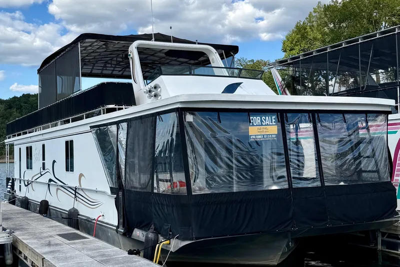 Slide: The Image of 2003 Horizon houseboat for sale, docked with covered upper deck and scenic background. - 2
