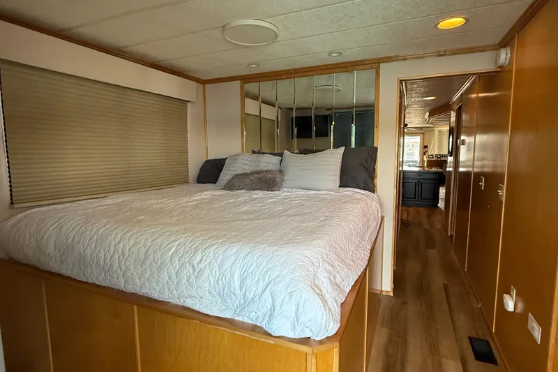 Slide: The Image of 2003 Horizon houseboat bedroom with cozy bed, wooden interior, and mirrored wall. - 22