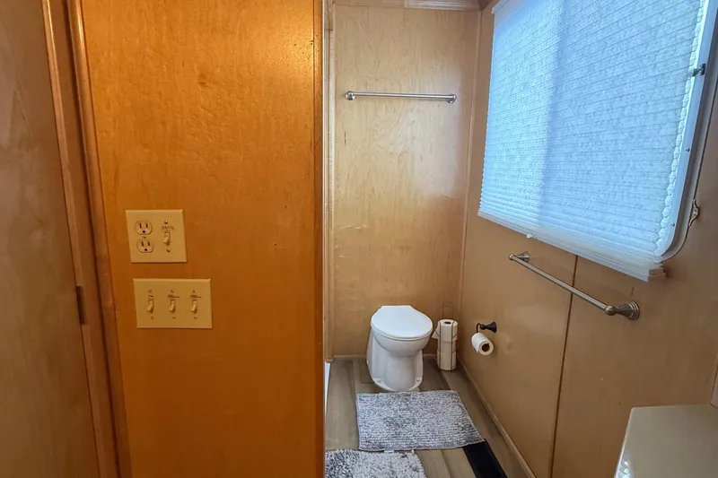 Slide: The Image of Houseboat bathroom with wooden walls, toilet, window blinds, and light switches, Horizon 2003 model. - 25