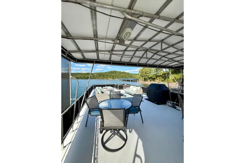 Slide: The Image of Spacious deck of 2003 Horizon houseboat with seating, grill, and scenic lake view. - 30