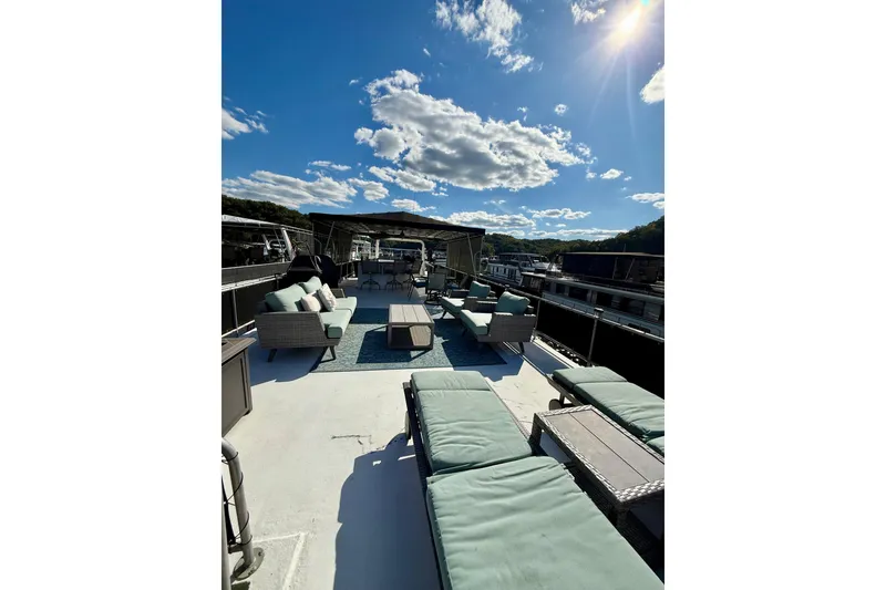 Slide: The Image of 2003 Horizon houseboat deck with lounge chairs, sofas, and a sunlit sky. - 32