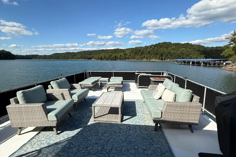Slide: The Image of Luxurious 2003 Horizon houseboat deck with comfortable seating, overlooking serene lake and lush greenery. - 33