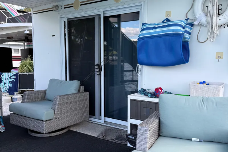 Slide: The Image of Cozy 2003 Horizon houseboat deck with wicker chairs and nautical decor. - 34