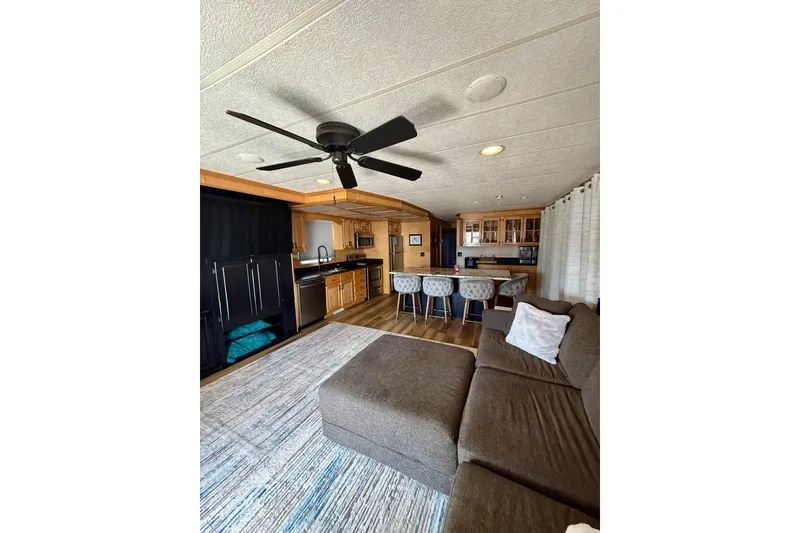Slide: The Image of Interior of 2003 Horizon houseboat with modern kitchen, cozy seating, and ceiling fan. - 7