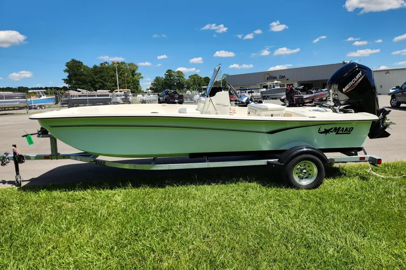 Slide: The Image of 2026 Mako Pro Skiff 17 CC boat on trailer, parked on grass under blue sky. - 5