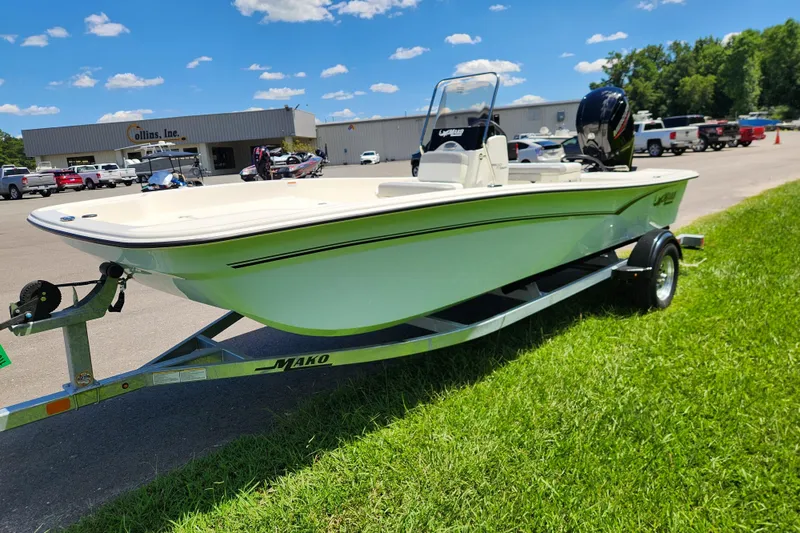 Slide: The Image of 2026 Mako Pro Skiff 17 CC boat on trailer, parked on grass near dealership. - 6