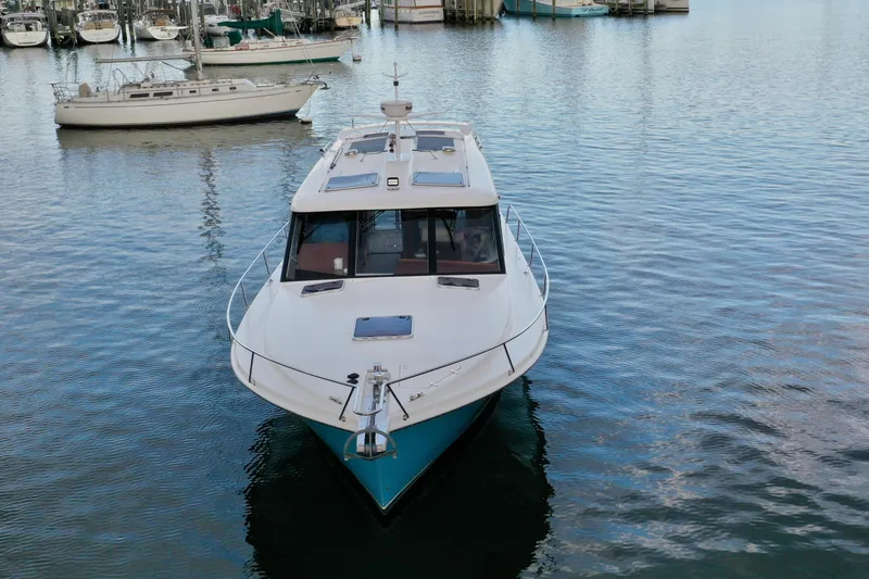 Slide: The Image of 2021 Hylas M44 yacht docked in a marina, surrounded by calm water and sailboats. - 23