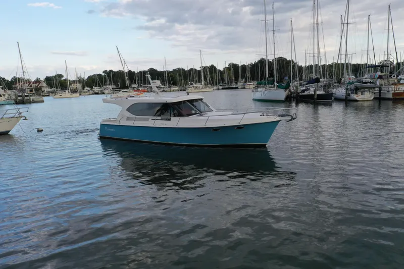 Slide: The Image of 2021 Hylas M44 yacht in a marina, surrounded by sailboats under a cloudy sky. - 26
