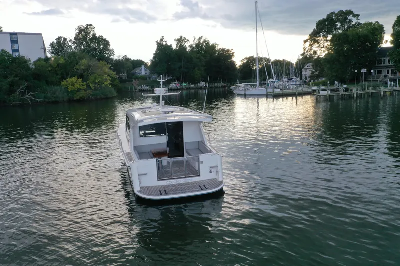 Slide: The Image of 2021 Hylas M44 yacht on calm water near a marina, surrounded by trees. - 28
