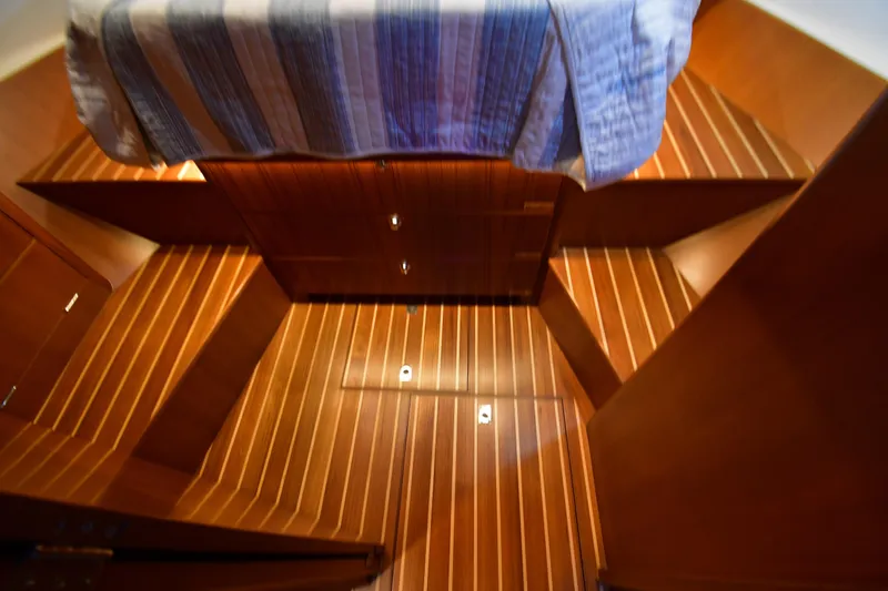 Slide: The Image of Interior of 2021 Hylas M44 yacht with wooden flooring and striped bedding. - 9