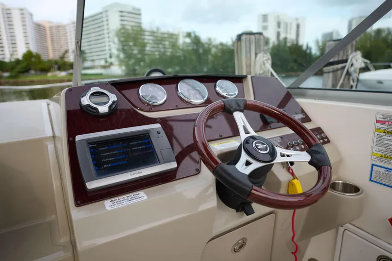 Slide: The Image of 2011 Sea Ray 260 Sundancer dashboard with steering wheel and navigation system. - 10