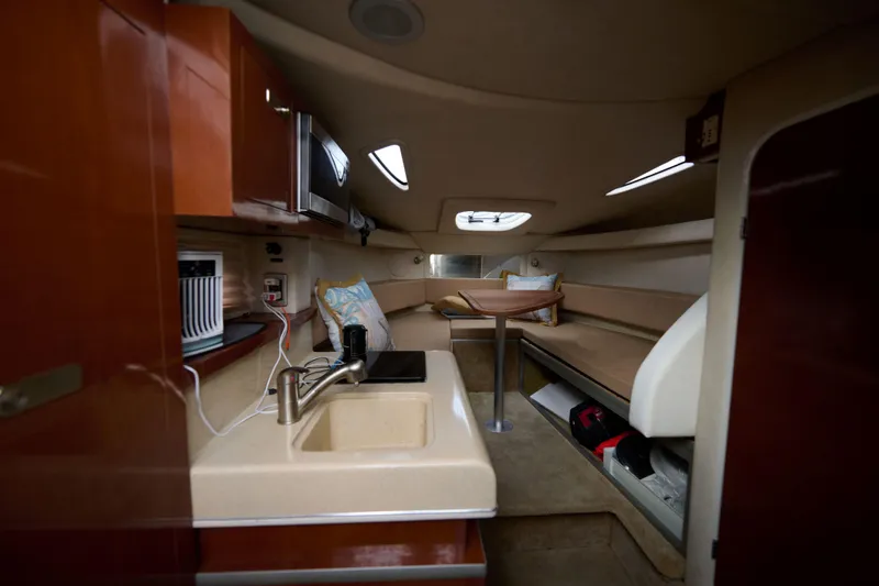 Slide: The Image of Interior of 2011 Sea Ray 260 Sundancer boat with kitchenette and seating area. - 12