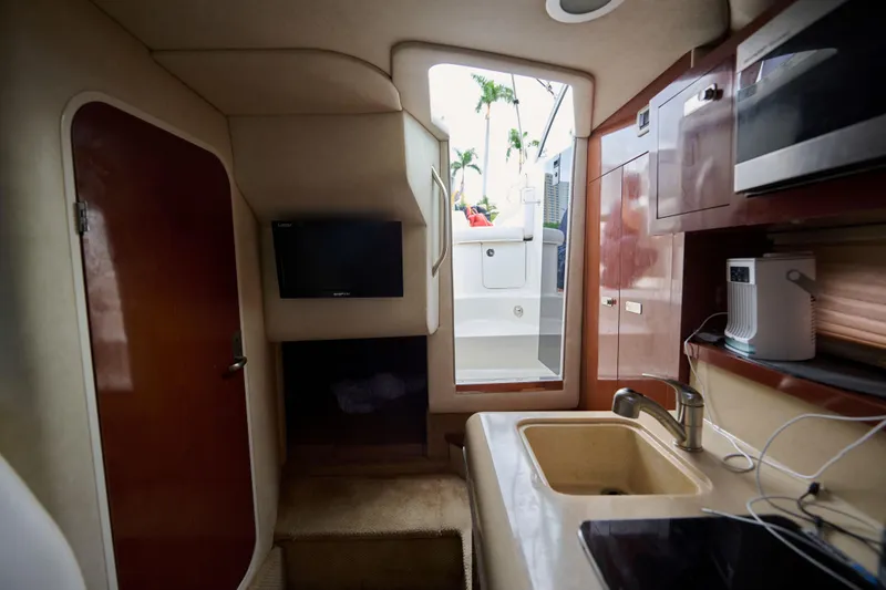 Slide: The Image of Interior of 2011 Sea Ray 260 Sundancer boat with kitchenette and TV. - 14