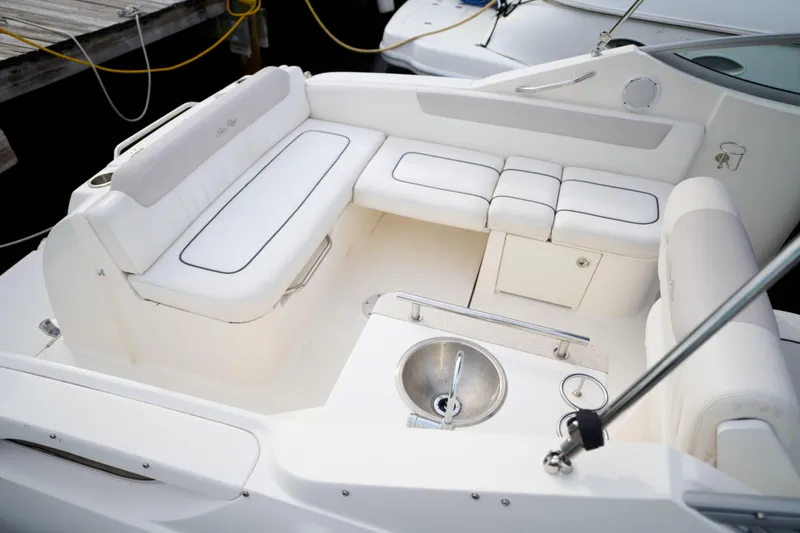 Slide: The Image of 2011 Sea Ray 260 Sundancer boat interior with white seating and stainless steel sink. - 6