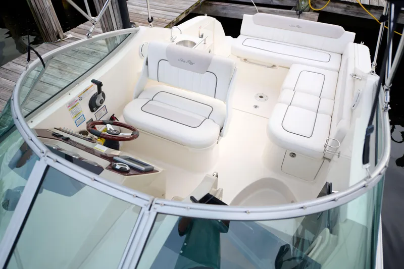 Slide: The Image of 2011 Sea Ray 260 Sundancer boat interior with white seating and steering wheel. - 7