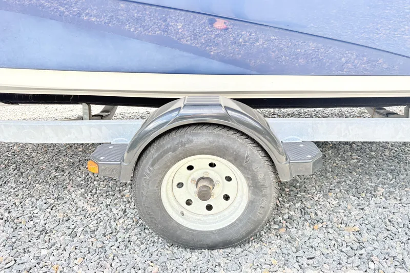 Slide: The Image of Trailer wheel of a 2014 Yamaha SX190 boat on gravel surface. - 3