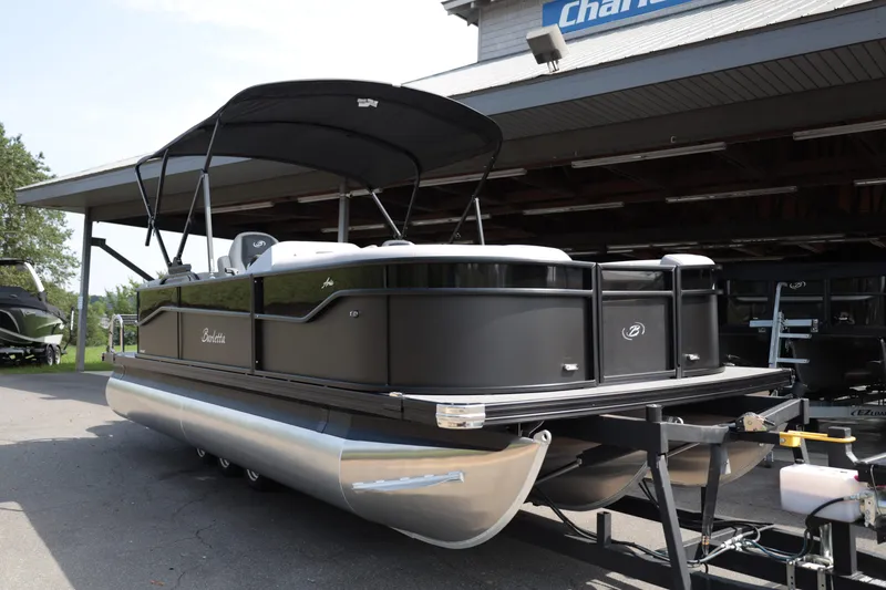 Slide: The Image of 2026 Barletta ARIA 22QC pontoon boat with black exterior, parked on a trailer. - 2
