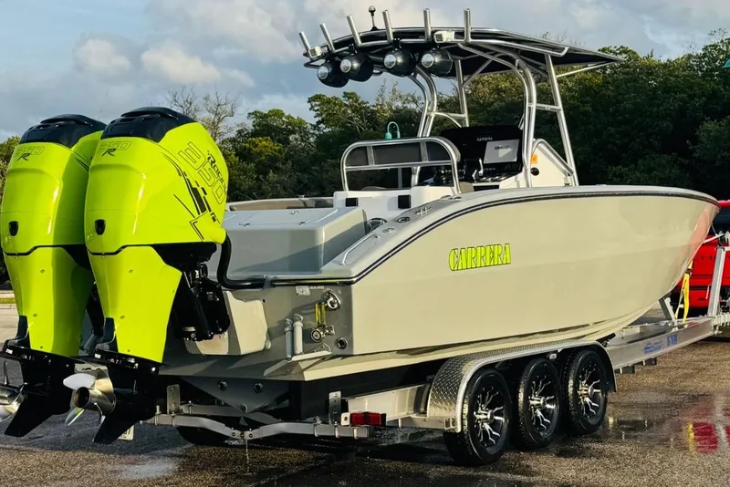Slide: The Image of 2005 Carrera Boats 32 on trailer, parked outdoors under cloudy sky. - 13