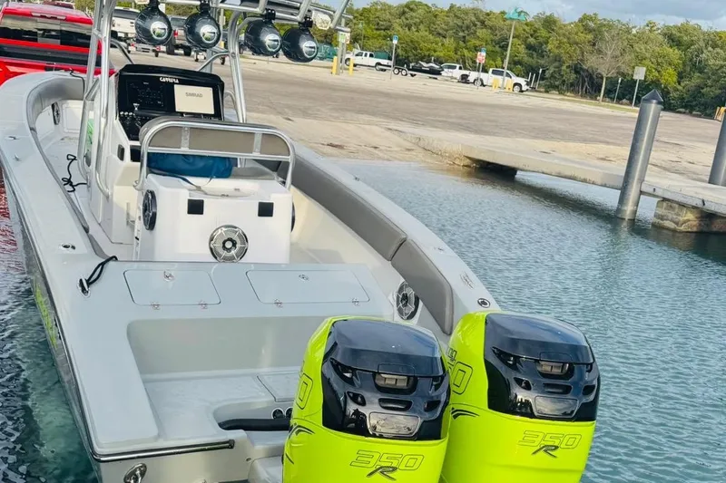 Slide: The Image of 2005 Carrera Boats 32 with twin neon green outboard motors docked on clear water. - 3
