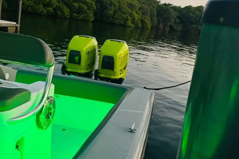 Slide: The Image of 2005 Carrera Boats 32 with dual neon green outboard motors on a trailer. - 14