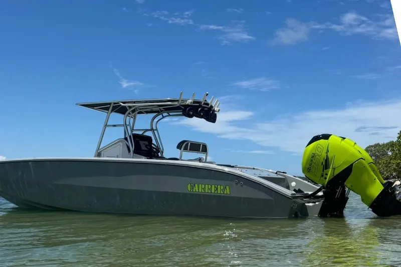 Slide: The Image of 2005 Carrera Boats 32 in water, featuring vibrant yellow engine, under clear blue sky. - 16
