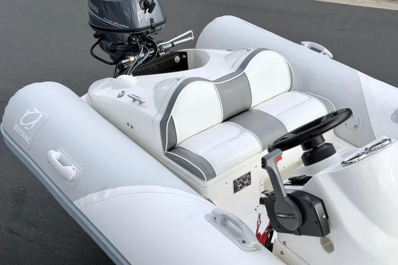 Slide: The Image of 2003 Zodiac Yachtline 340DL inflatable boat with Yamaha outboard motor, featuring white and gray seating. - 14
