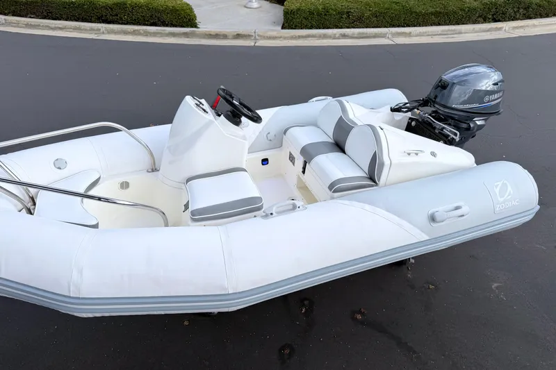 Slide: The Image of 2003 Zodiac Yachtline 340DL inflatable boat with Yamaha outboard motor, parked on pavement. - 17