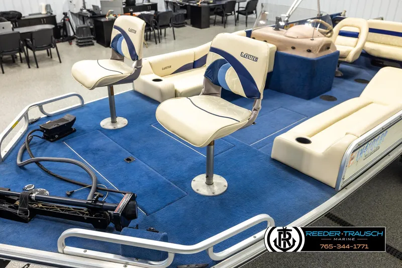 Slide: The Image of 1998 Lowe LS 2220 boat interior with blue carpet and cream seats in showroom. - 10