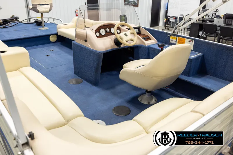 Slide: The Image of Interior of a 1998 Lowe LS 2220 boat with blue carpet and beige seating. - 11