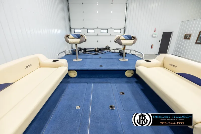 Slide: The Image of Interior of a 1998 Lowe LS 2220 boat with blue carpet and beige seating. - 16