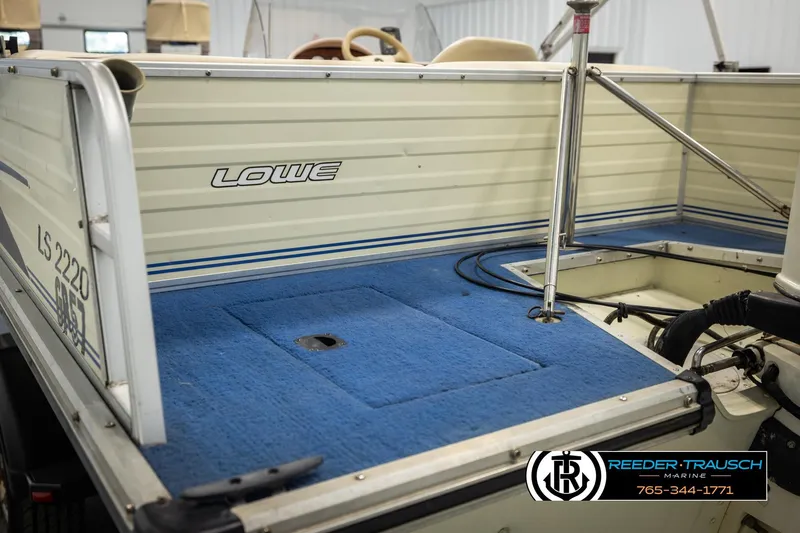Slide: The Image of 1998 Lowe LS 2220 boat interior with blue carpet and branded logo. - 22