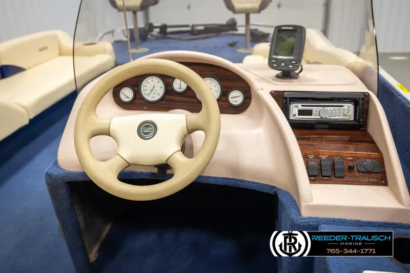 Slide: The Image of 1998 Lowe LS 2220 boat dashboard with steering wheel, gauges, and navigation equipment. - 24