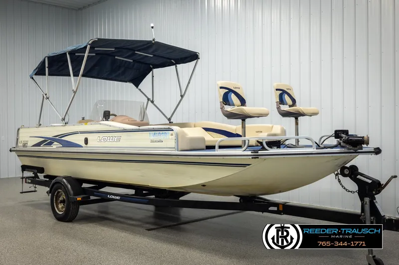 Slide: The Image of 1998 Lowe LS 2220 boat with canopy on trailer, displayed indoors. - 3