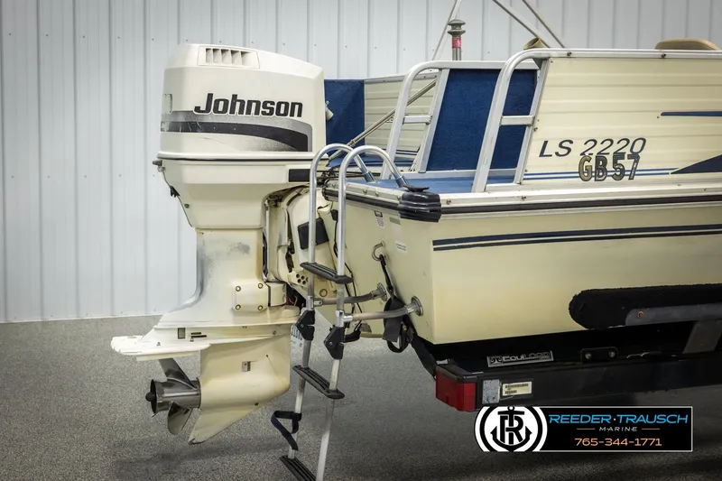 Slide: The Image of 1998 Lowe LS 2220 boat with Johnson outboard motor, displayed indoors. - 42
