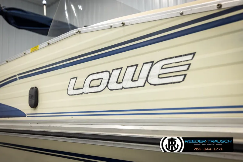Slide: The Image of 1998 Lowe LS 2220 boat side view with logo and blue stripes. - 48