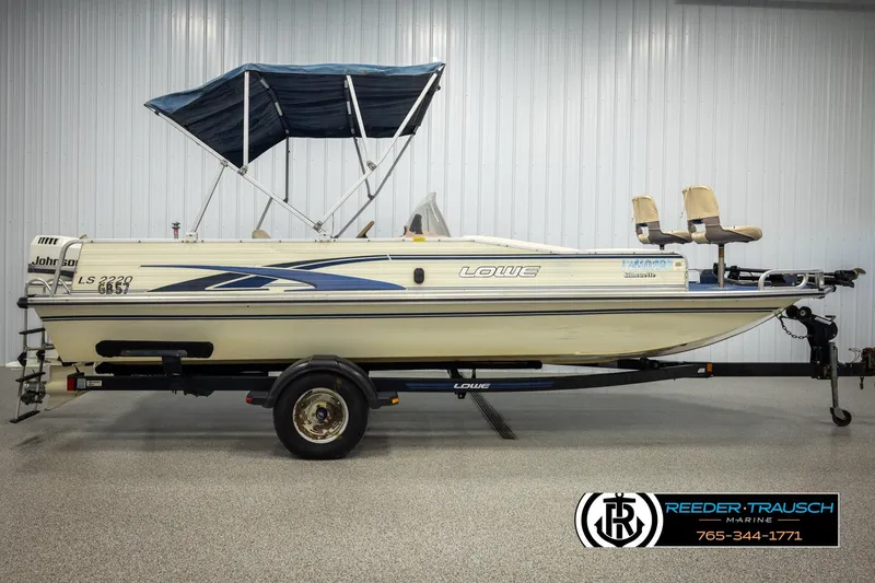 Slide: The Image of 1998 Lowe LS 2220 boat with canopy on trailer in showroom. - 5