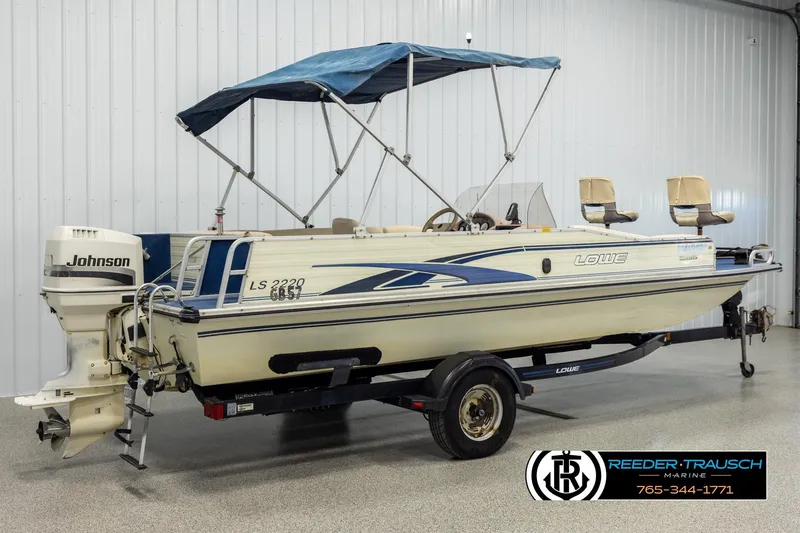 Slide: The Image of 1998 Lowe LS 2220 boat with Johnson outboard motor and blue canopy on trailer. - 6