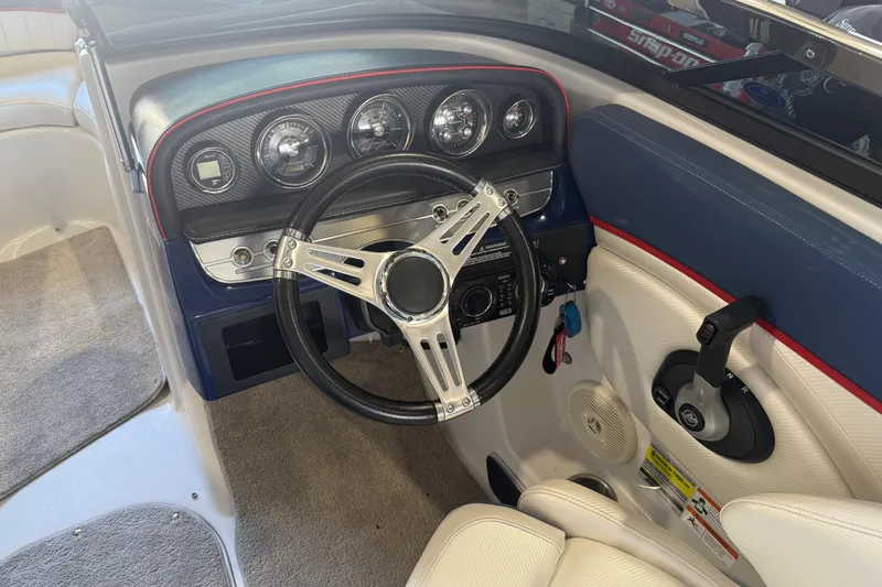 Slide: The Image of 2011 FOURWINNS 210 boat dashboard with steering wheel and control panel. - 4