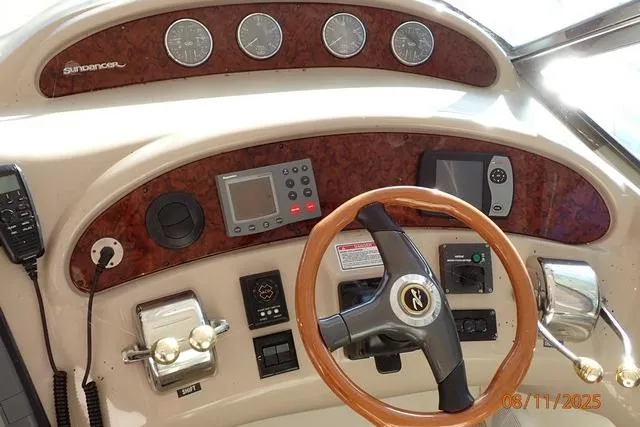 Slide: The Image of Control panel of 2003 Sea Ray 460 Sundancer yacht with steering wheel and navigation instruments. - 2