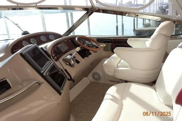 Slide: The Image of Interior cockpit of a 2003 Sea Ray 460 Sundancer yacht with white seating and control panel. - 26