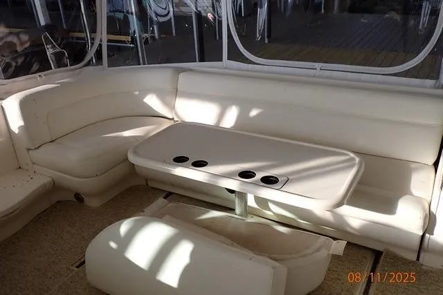 Slide: The Image of 2003 Sea Ray 460 Sundancer interior with white seating and table, featuring cup holders. - 31