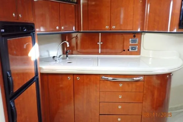 Slide: The Image of 2003 Sea Ray 460 Sundancer yacht kitchen with wood cabinets and modern appliances. - 43