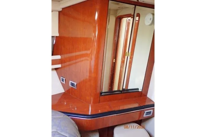 Slide: The Image of 2003 Sea Ray 460 Sundancer cabin interior with wood finish and mirrored cabinet. - 46