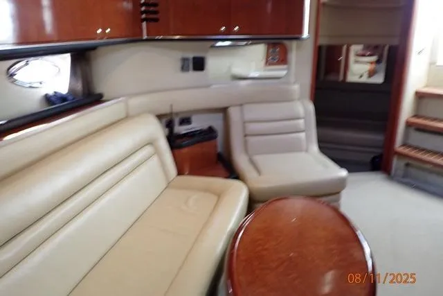 Slide: The Image of Interior of 2003 Sea Ray 460 Sundancer yacht with beige seating and wooden accents. - 49