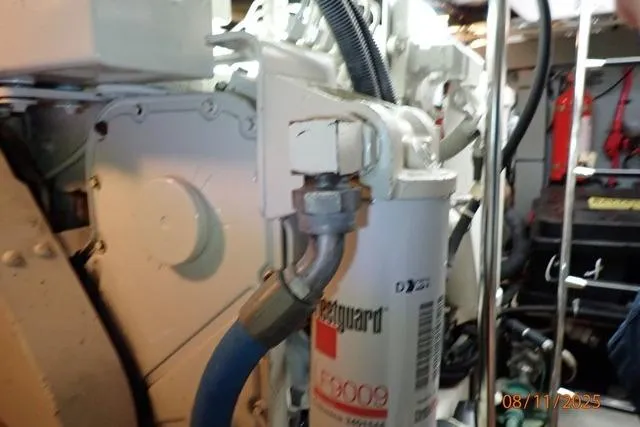 Slide: The Image of Engine room of 2003 Sea Ray 460 Sundancer with visible oil filter and hoses. - 53