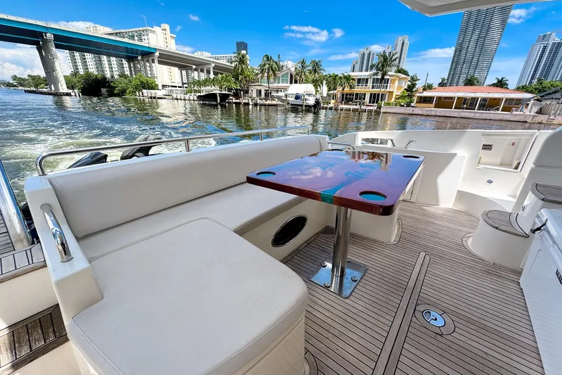Slide: The Image of Luxurious 2012 Azimut Fly 53 yacht deck with seating, table, and scenic waterfront view. - 12