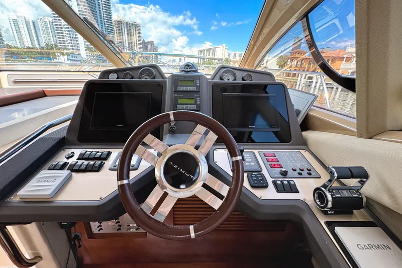 Slide: The Image of Cockpit of 2012 Azimut Fly 53 yacht with modern navigation controls and cityscape view. - 27