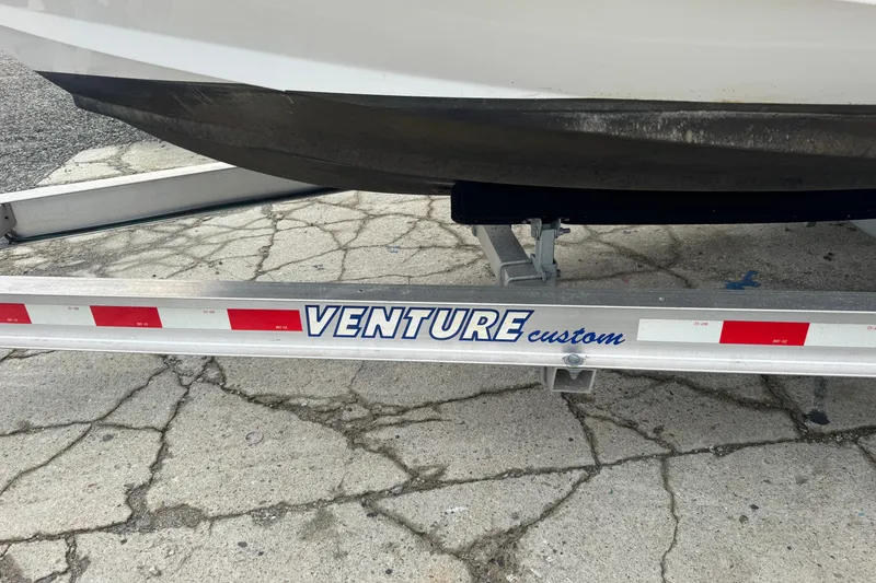 Slide: The Image of Trailer for 2023 Edgewater 208CC boat on cracked pavement. - 10